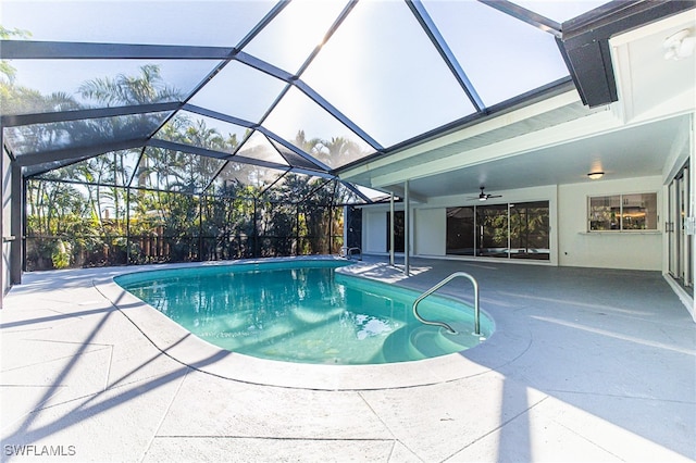 view of swimming pool featuring ceiling fan, a patio area, and glass enclosure