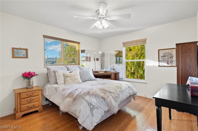 bedroom with light wood-type flooring, multiple windows, and ceiling fan