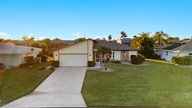 ranch-style home with a garage and a front lawn