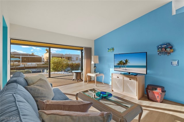 living room with light hardwood / wood-style floors and lofted ceiling