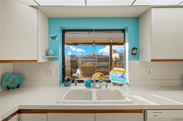 kitchen featuring white cabinetry, sink, and dishwasher