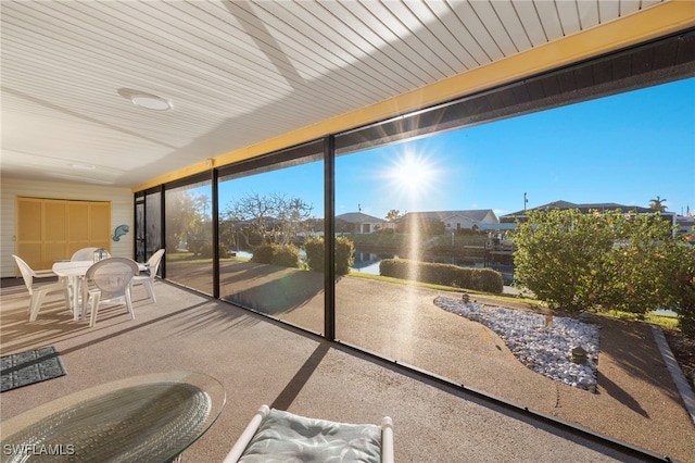 sunroom / solarium featuring a water view