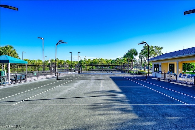 view of tennis court with basketball hoop