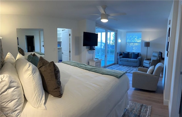 bedroom with hardwood / wood-style flooring, ceiling fan, a spacious closet, and access to outside