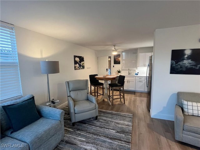 living room with hardwood / wood-style flooring, sink, and ceiling fan