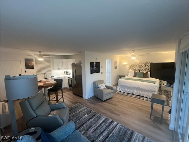 bedroom with hardwood / wood-style flooring and stainless steel refrigerator with ice dispenser