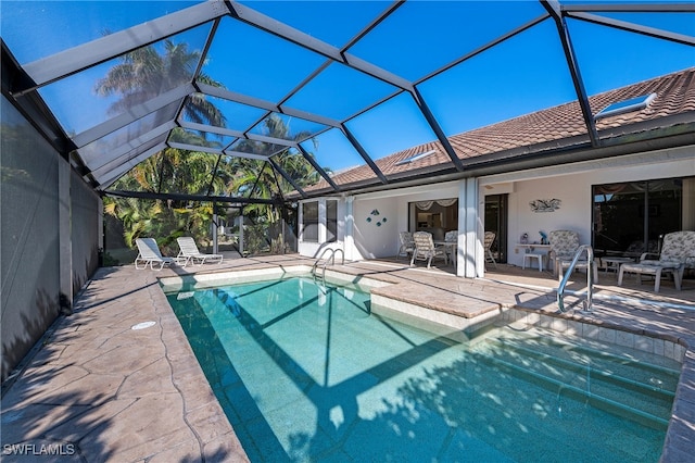 view of swimming pool with glass enclosure and a patio area