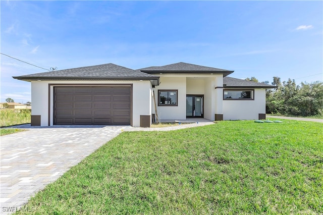 prairie-style home featuring french doors, a garage, and a front lawn