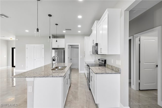 kitchen featuring pendant lighting, a kitchen island with sink, sink, appliances with stainless steel finishes, and white cabinetry