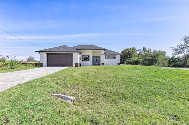 prairie-style home with a garage and a front lawn