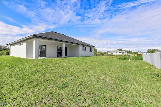 back of property featuring a patio area and a yard