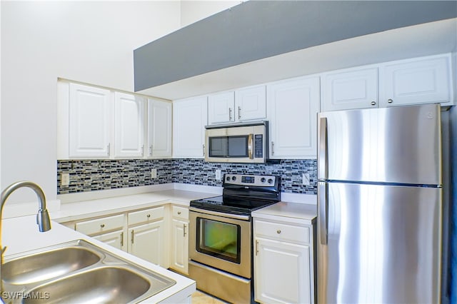 kitchen with decorative backsplash, white cabinetry, sink, and appliances with stainless steel finishes