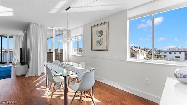 dining room with plenty of natural light, dark hardwood / wood-style flooring, and a chandelier