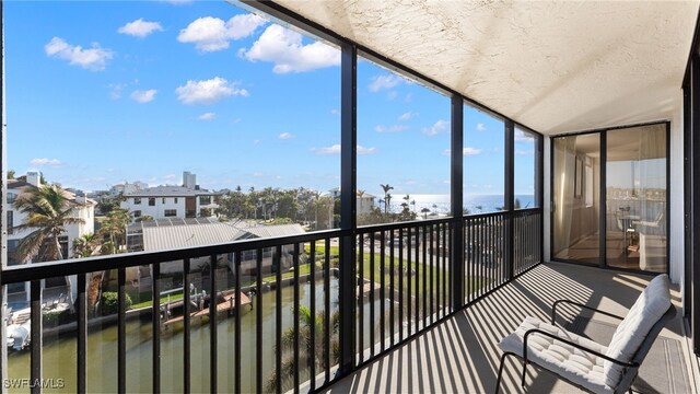 sunroom featuring a water view