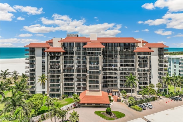 view of building exterior featuring a water view and a view of the beach