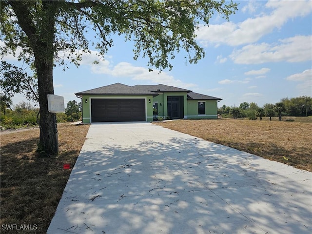 view of front of home with an attached garage, driveway, and stucco siding