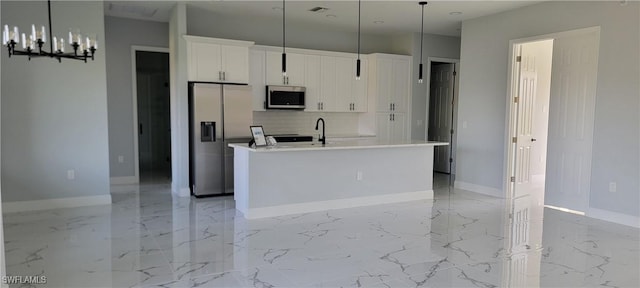 kitchen featuring baseboards, white cabinets, a kitchen island with sink, stainless steel appliances, and marble finish floor