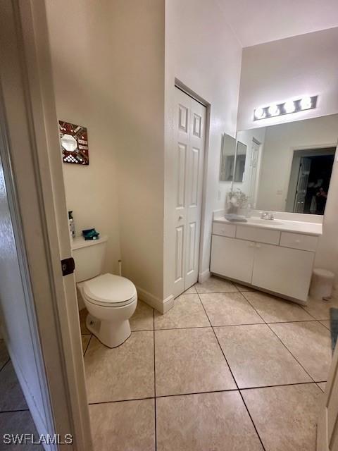 bathroom with tile patterned flooring, vanity, and toilet