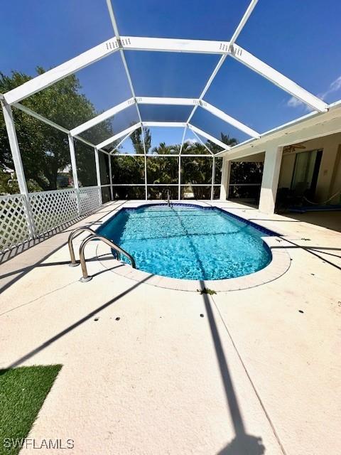 view of pool featuring glass enclosure and a patio area