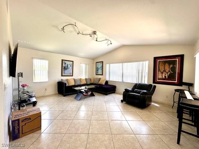 tiled living room featuring vaulted ceiling