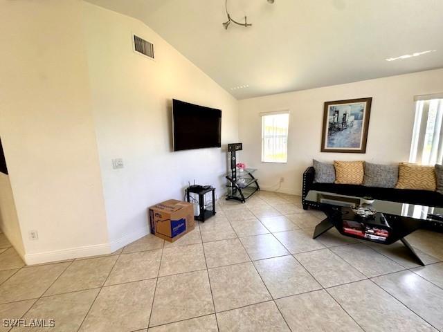 living room featuring light tile patterned floors and vaulted ceiling