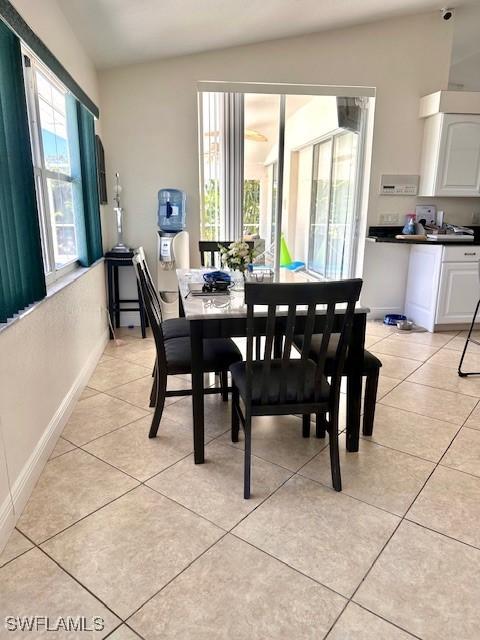 tiled dining space featuring lofted ceiling