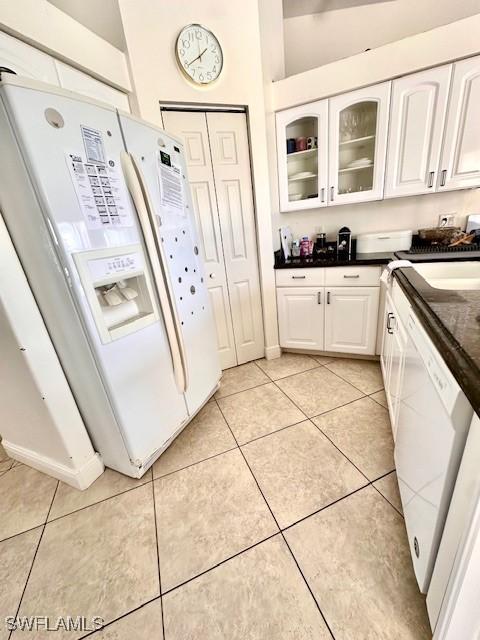 kitchen featuring white cabinets, white appliances, sink, and light tile patterned floors