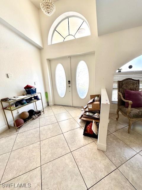 entryway with light tile patterned floors and a high ceiling