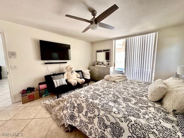 bedroom with light tile patterned floors, a textured ceiling, and ceiling fan