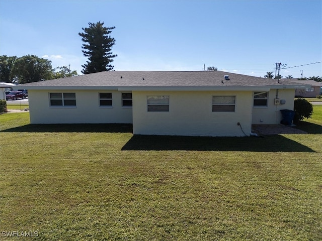 rear view of house featuring a yard