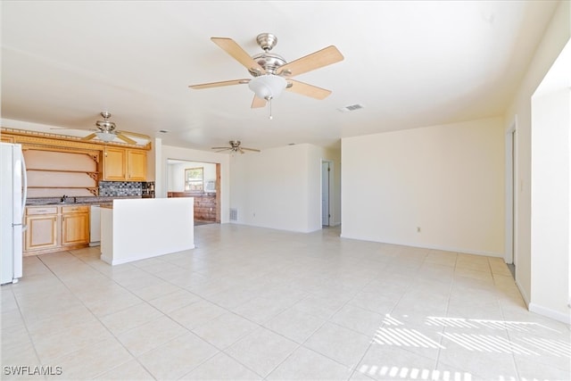 unfurnished living room featuring sink and light tile patterned floors