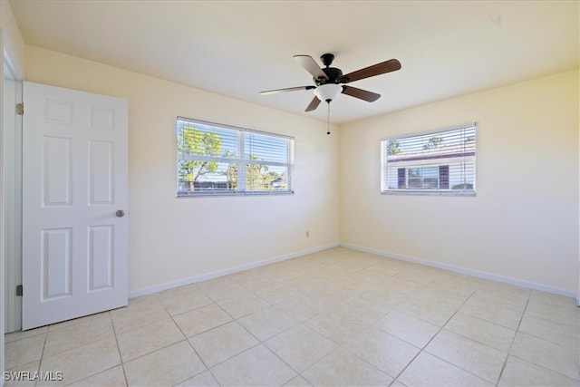 spare room with ceiling fan and light tile patterned flooring