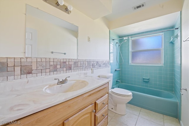 full bathroom with tasteful backsplash, tile patterned flooring, toilet, vanity, and tiled shower / bath