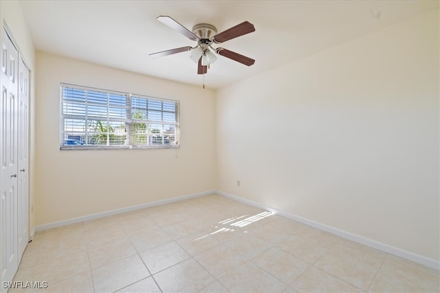 tiled spare room featuring ceiling fan