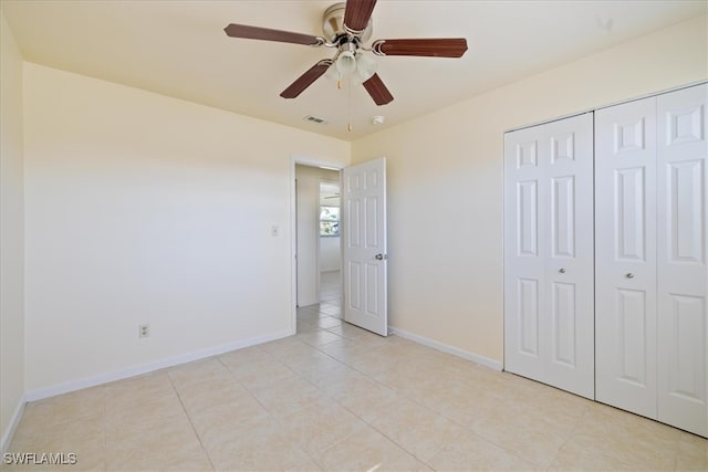 unfurnished bedroom with ceiling fan, light tile patterned floors, and a closet