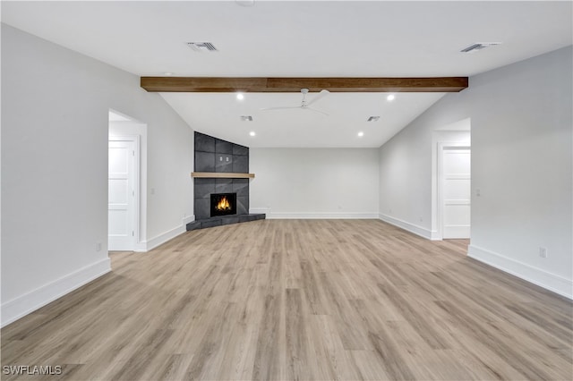 unfurnished living room with a tile fireplace, vaulted ceiling with beams, light hardwood / wood-style flooring, and ceiling fan