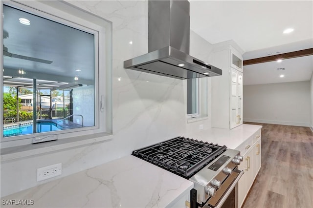 381 Norwood Ct, Fort Myers, FL 33919 - kitchen featuring island exhaust hood, stainless steel gas range, glass insert cabinets, white cabinets, and light stone counters