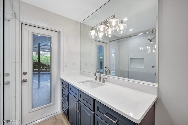 bathroom featuring hardwood / wood-style flooring, vanity, and walk in shower