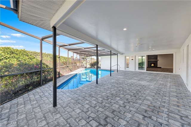 view of swimming pool featuring ceiling fan, a patio area, and glass enclosure