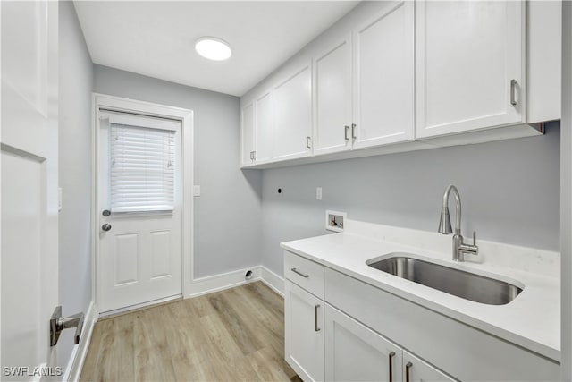 laundry area featuring cabinets, washer hookup, electric dryer hookup, sink, and light hardwood / wood-style flooring