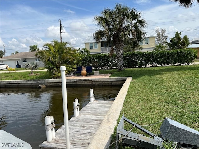 view of dock with a water view and a lawn