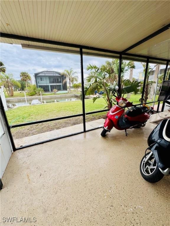 unfurnished sunroom featuring a water view