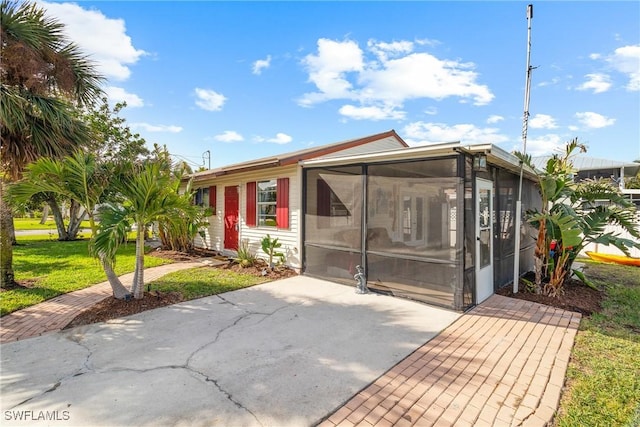 view of front of property featuring a sunroom and a front yard