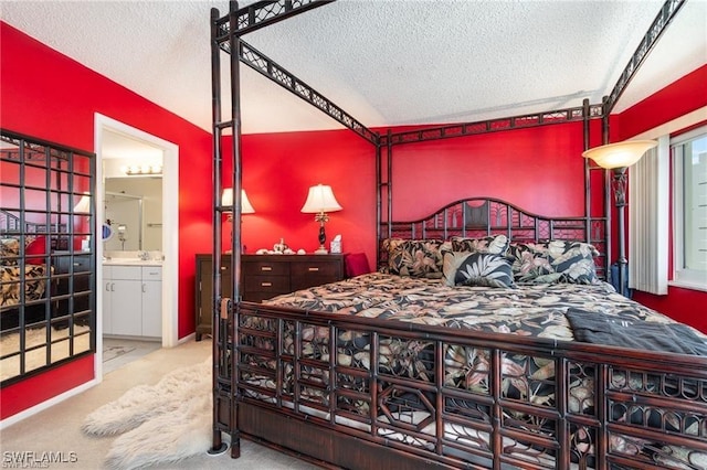 carpeted bedroom with sink, ensuite bath, and a textured ceiling