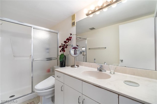 bathroom featuring vanity, an enclosed shower, and toilet