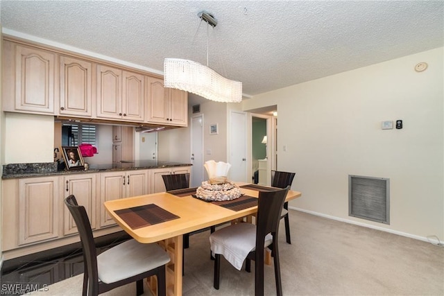 dining space featuring light carpet and a textured ceiling