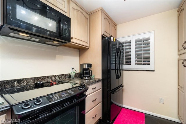 kitchen with dark stone countertops, light brown cabinetry, and black appliances