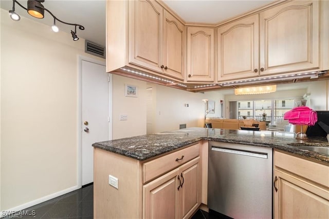 kitchen featuring dark stone countertops, dark tile patterned floors, stainless steel dishwasher, kitchen peninsula, and light brown cabinets