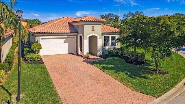 mediterranean / spanish home with a garage and a front lawn