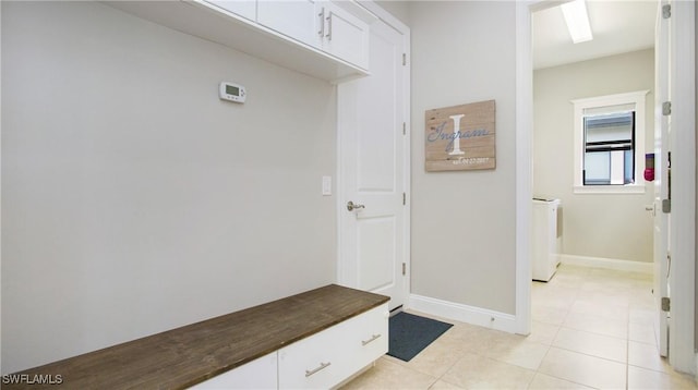 mudroom with light tile patterned flooring and washing machine and dryer